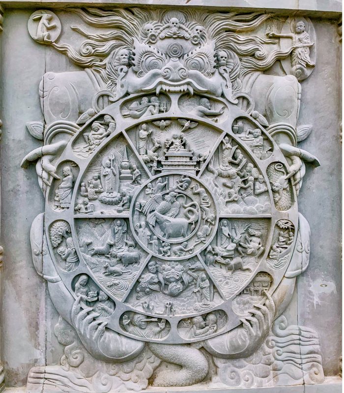 A stone relief of the Bhavacakra (Wheel of Life) at the Vipassana Meditation Center, India, set up by a Myanmar-based Buddhist group.