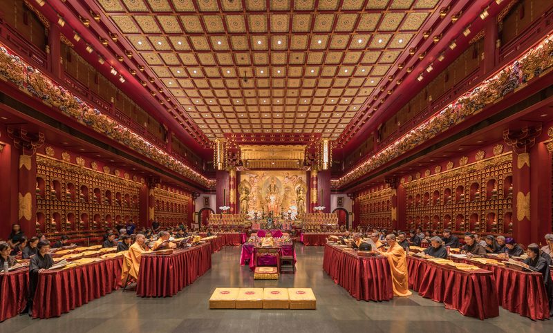 Buddhist monastics and laypeople chanting sutras in the Buddha Tooth Relic Temple, Singapore.