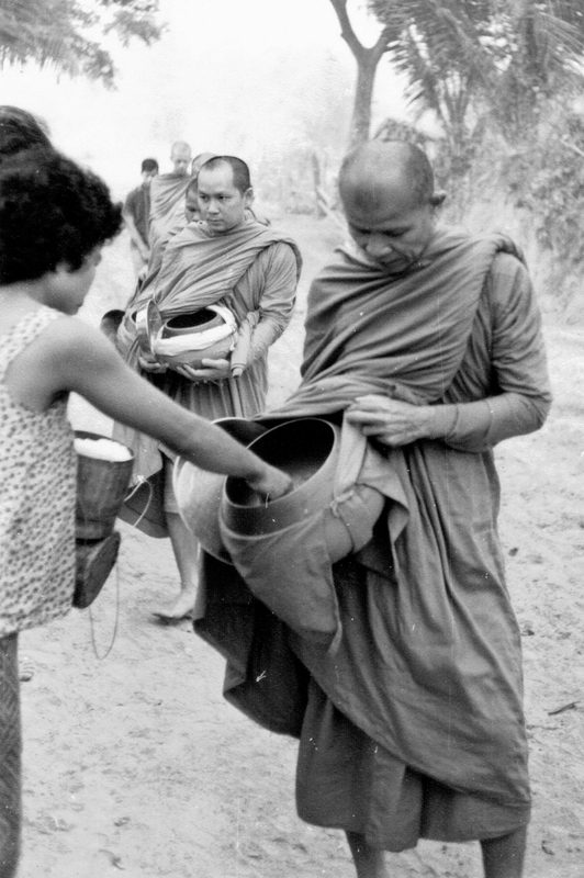 Thai forest tradition monks led by Ajahn Maha Bua out for the morning alms round.