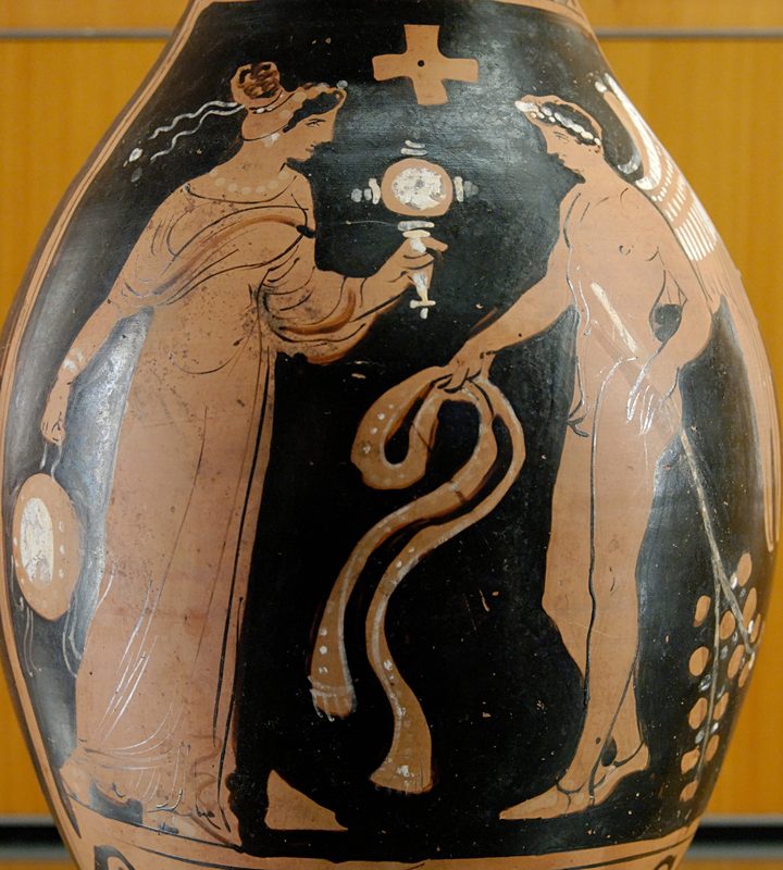 Winged genius facing a woman with a tambourine and mirror, from southern Italy, about 320 BCE.